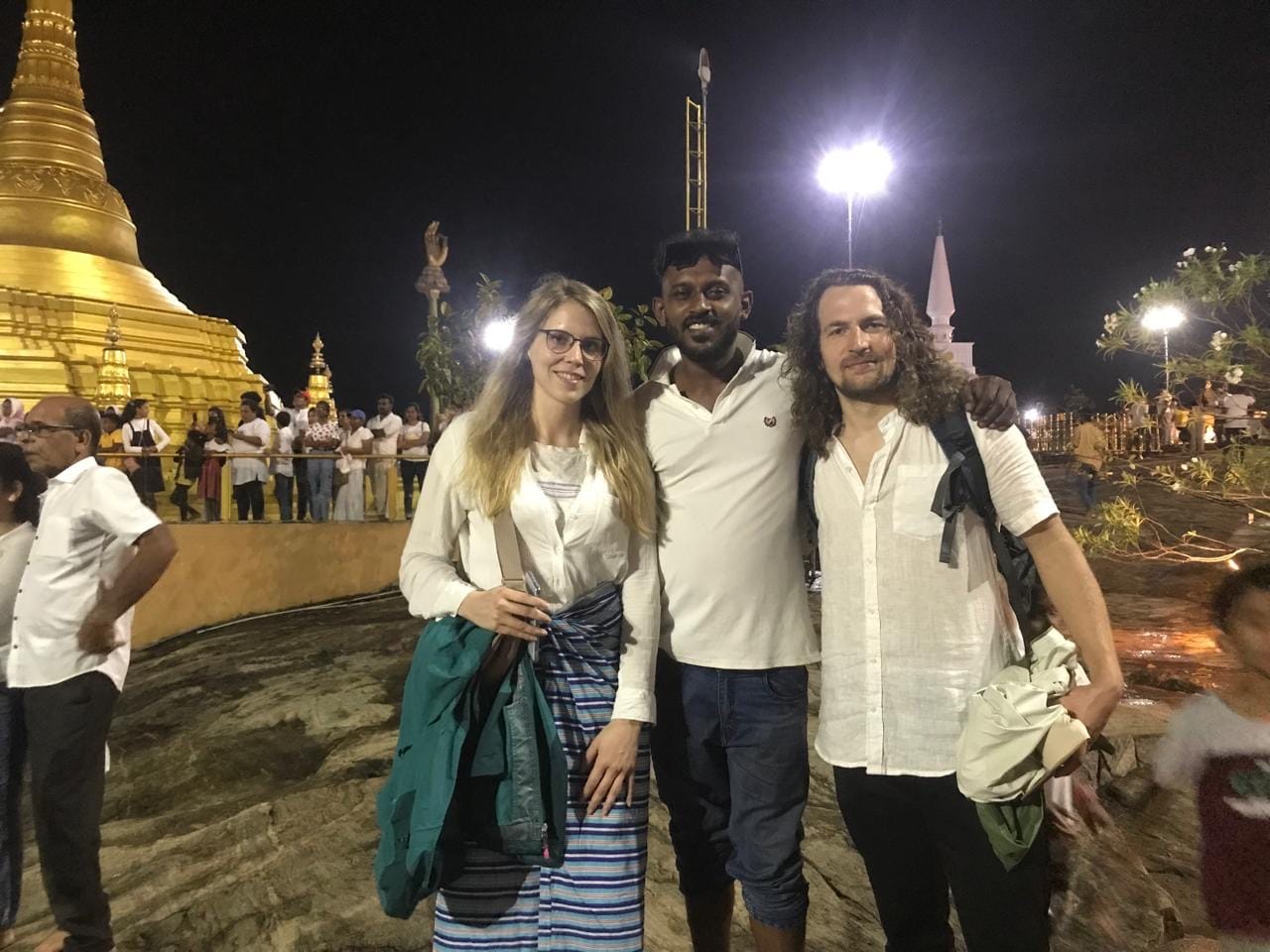 Tourists visiting sacred Buddhist temple at night during Kandy temples tour in Sri Lanka